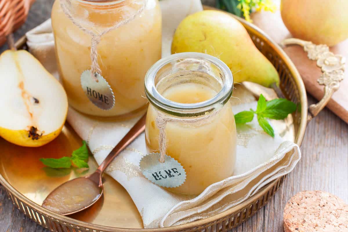 Homemade pear jam on wooden board on background fresh ripe pears