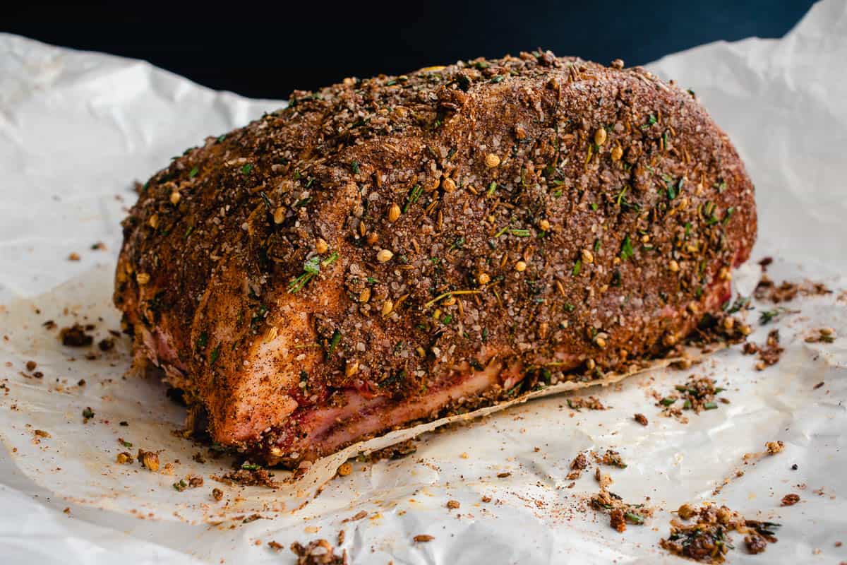 Uncooked rib roast covered in a spice rub.