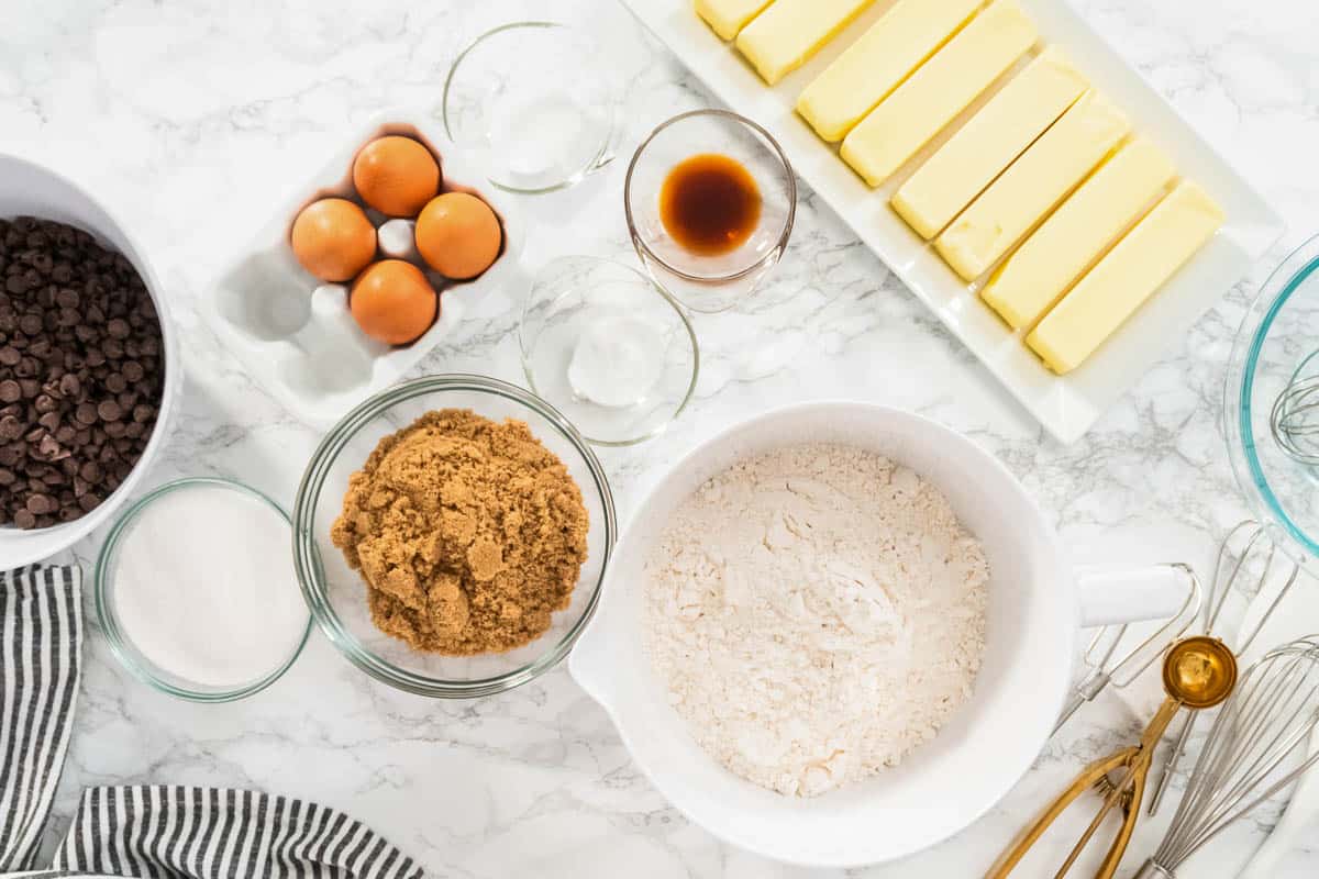 Mixing ingredients in a glass mixing bowl to bake chocolate chip cookies.