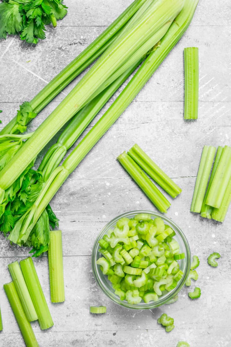 Pieces of celery in a glass bowl. On rustic background.