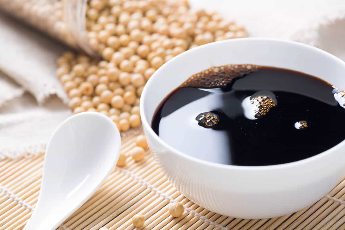 Soy sauce in dish with dried soy beans.