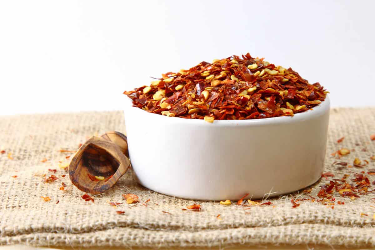 Crushed red pepper flakes in a ceramic bowl.