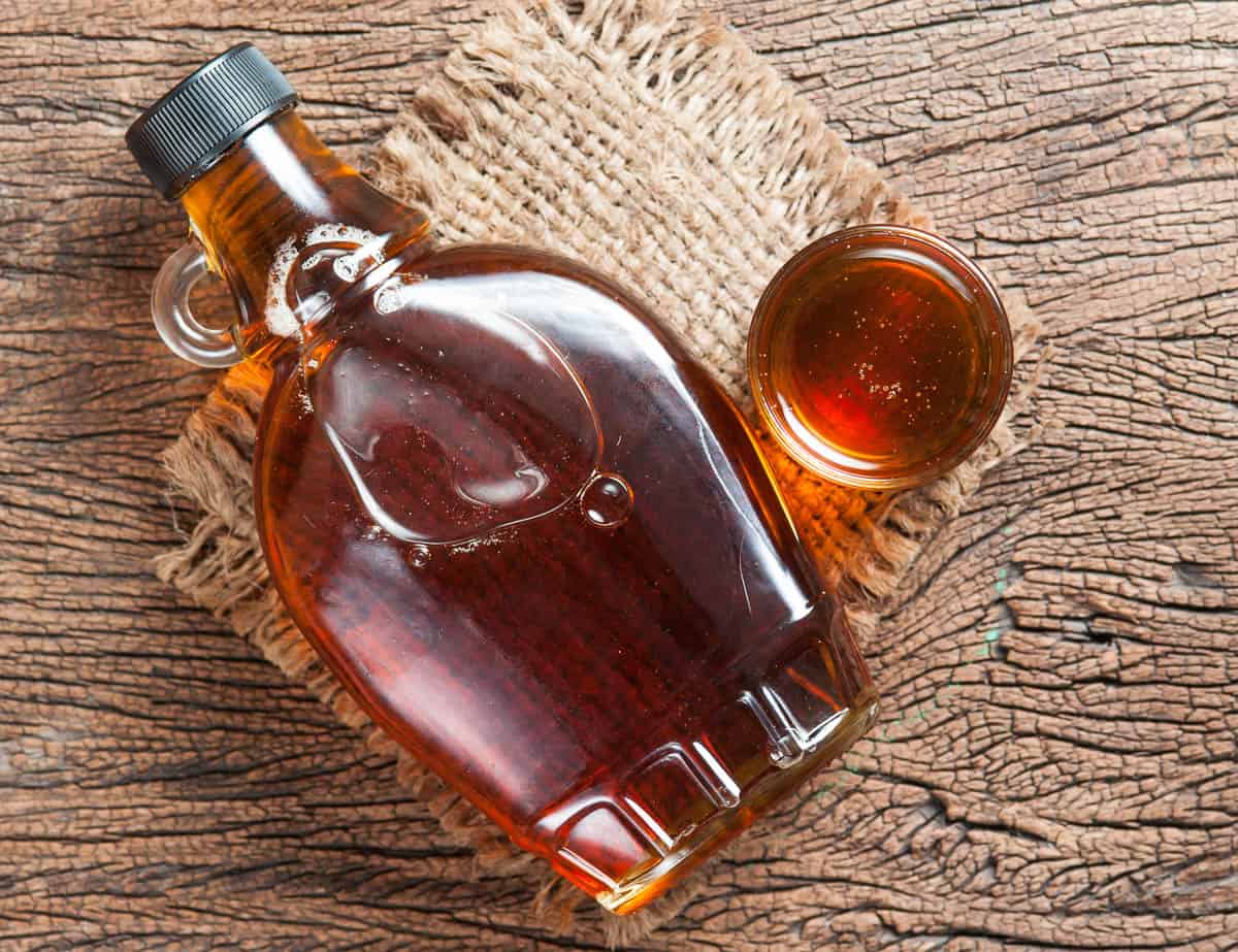 maple syrup in glass bottle on wooden table.