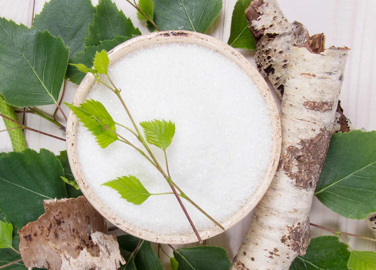 Xylitol - sugar substitute for diabetics. Birch sugar on white wooden background.