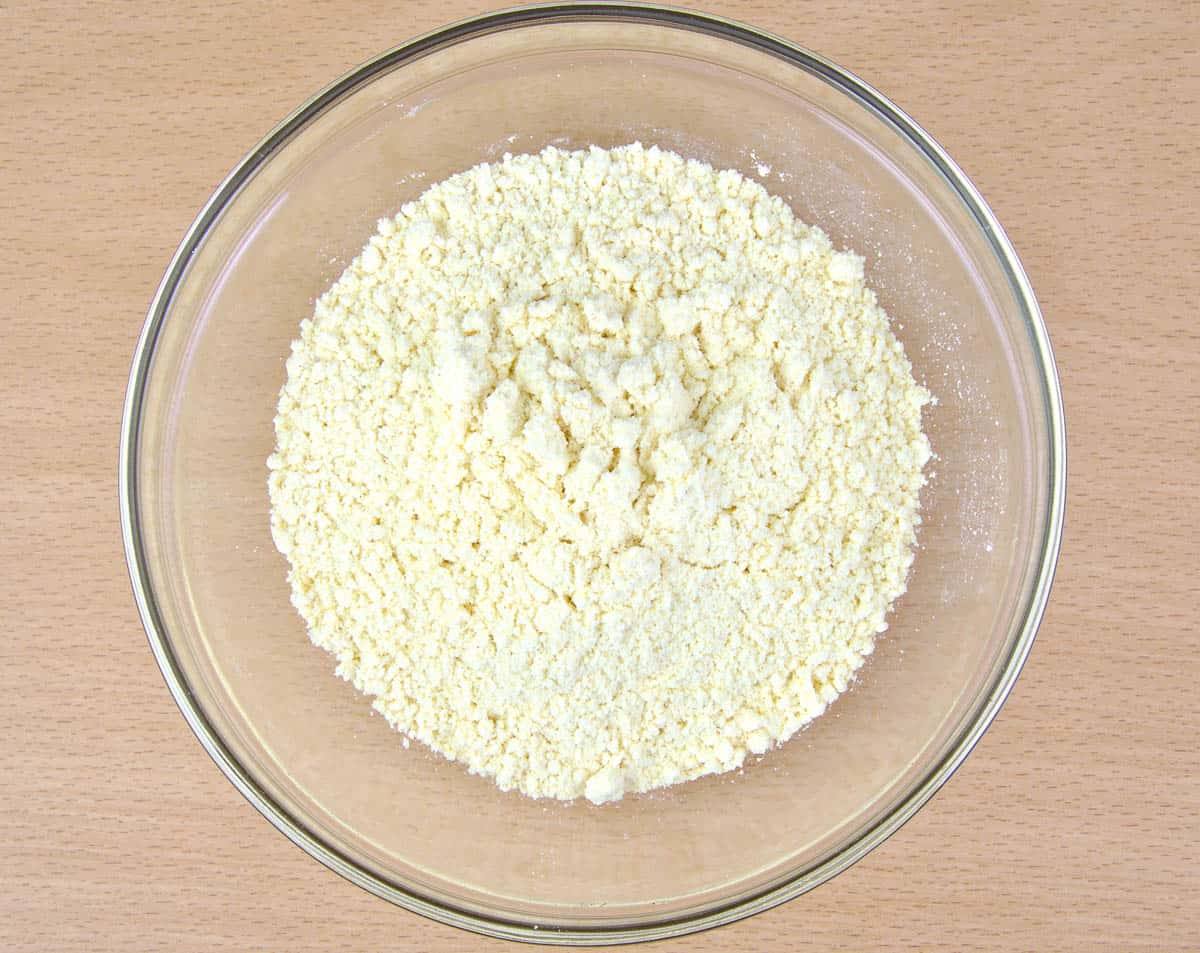 Cornflour in a glass bowl on wooden background.