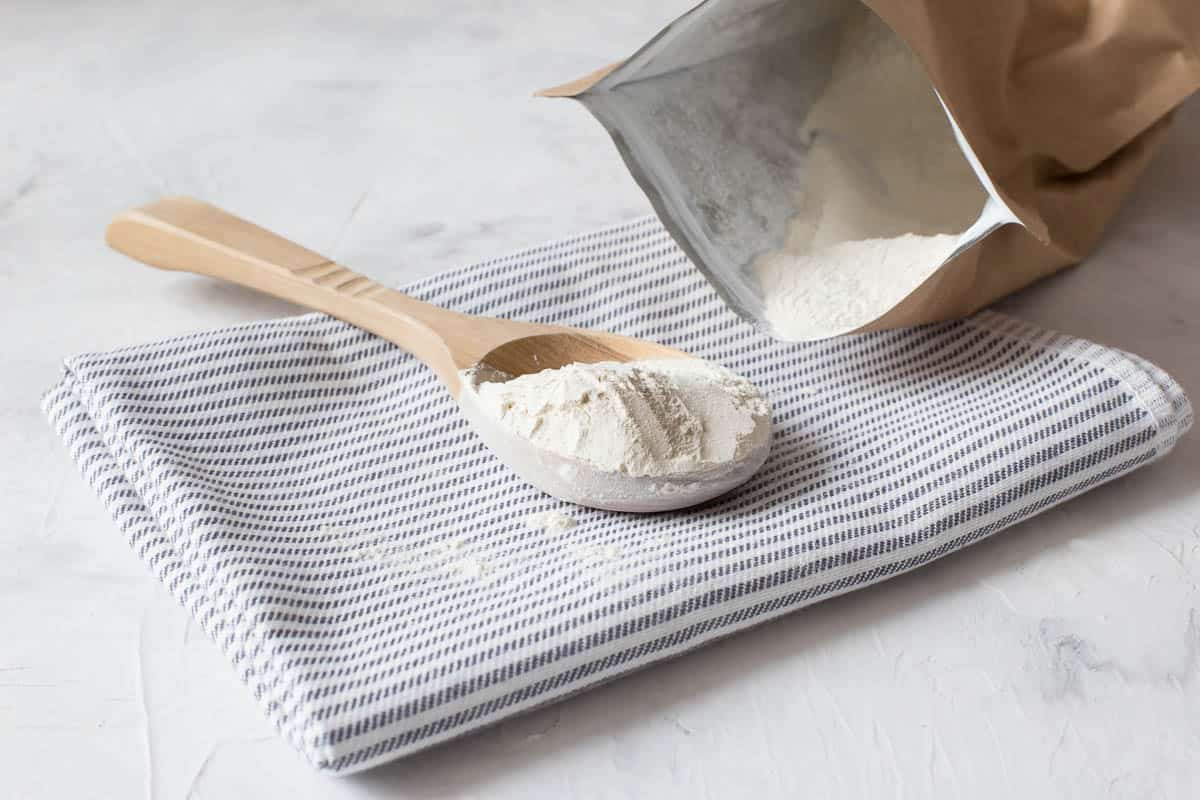 Crumbly xanthan gum in a wooden spoon. Natural thickening agent used in cooking.