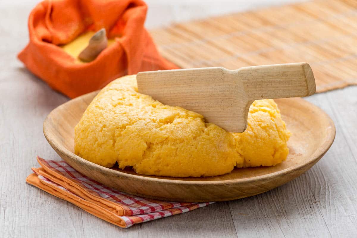 Italian polenta with wood knife stuck in it.