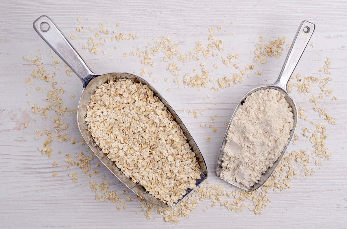 Flour made from oats. Rolled oats. Light wooden background.