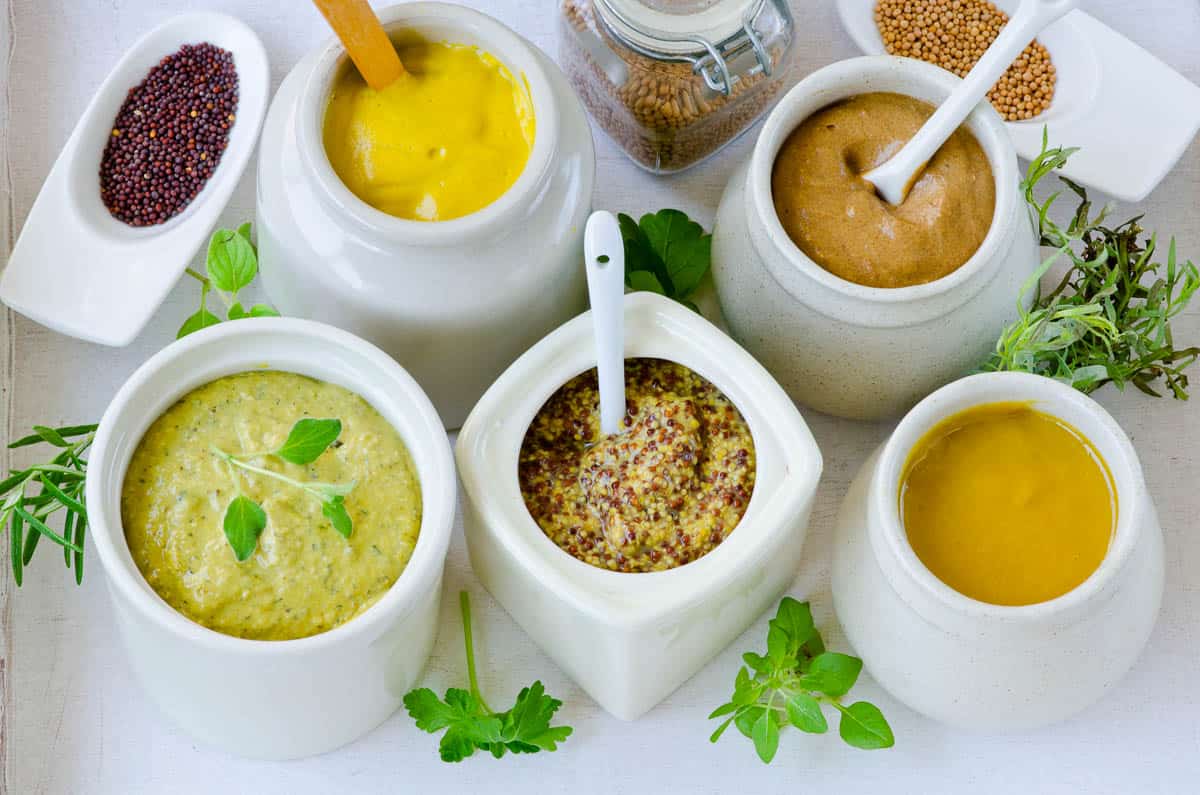 Variety of Mustard sauces and mustard seeds.