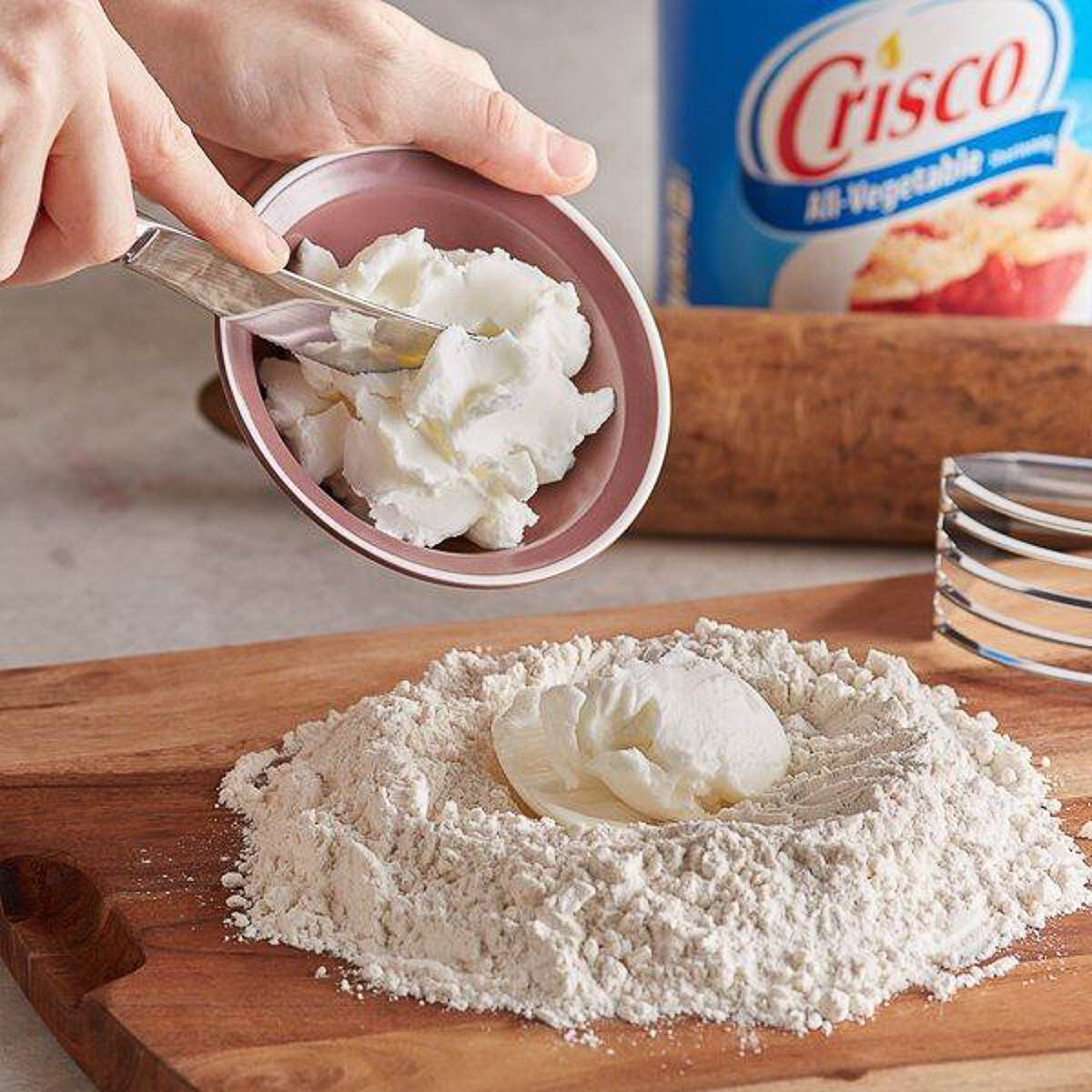 adding crisco to flour for pie dough.