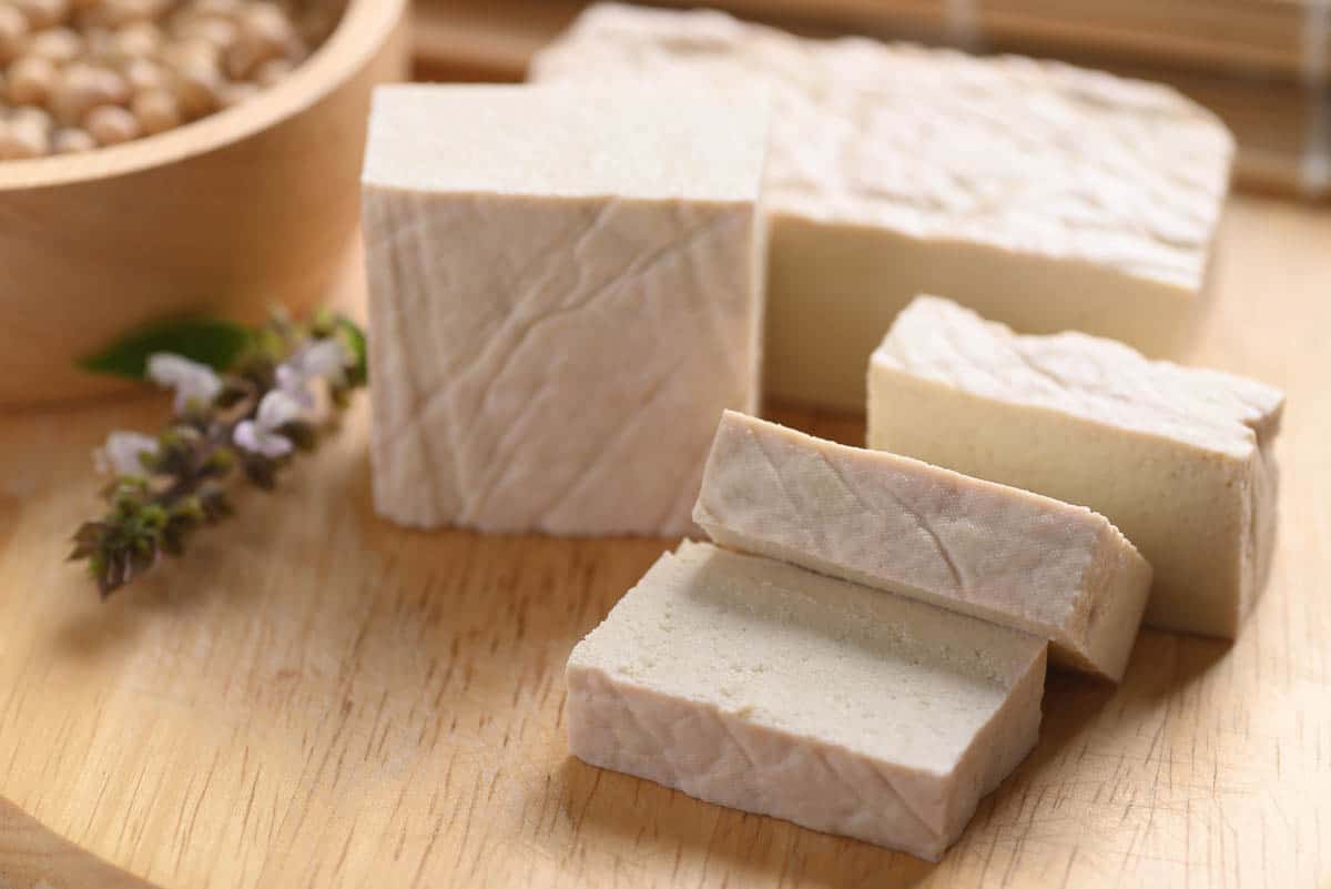 Fresh Tofu on wooden cutting board.