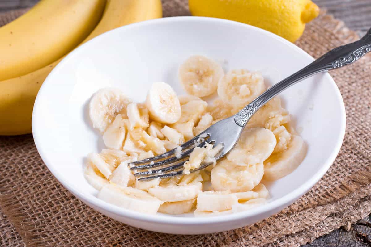 Slices of banana in a bowl and fork.