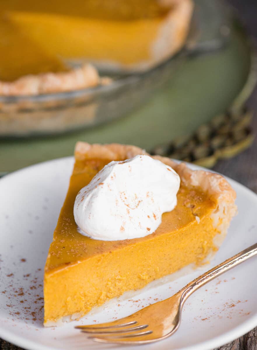 homemade pumpkin pie topped with whipped cream
