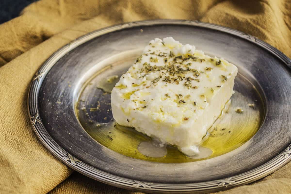 fresh feta cheese topped with herbs and drizzled with olive oil