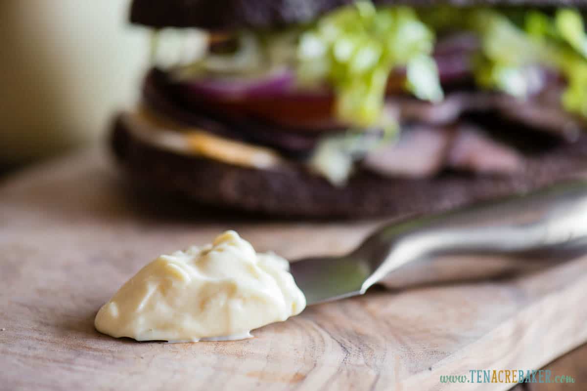 mayonnaise on knife in front of sandwich