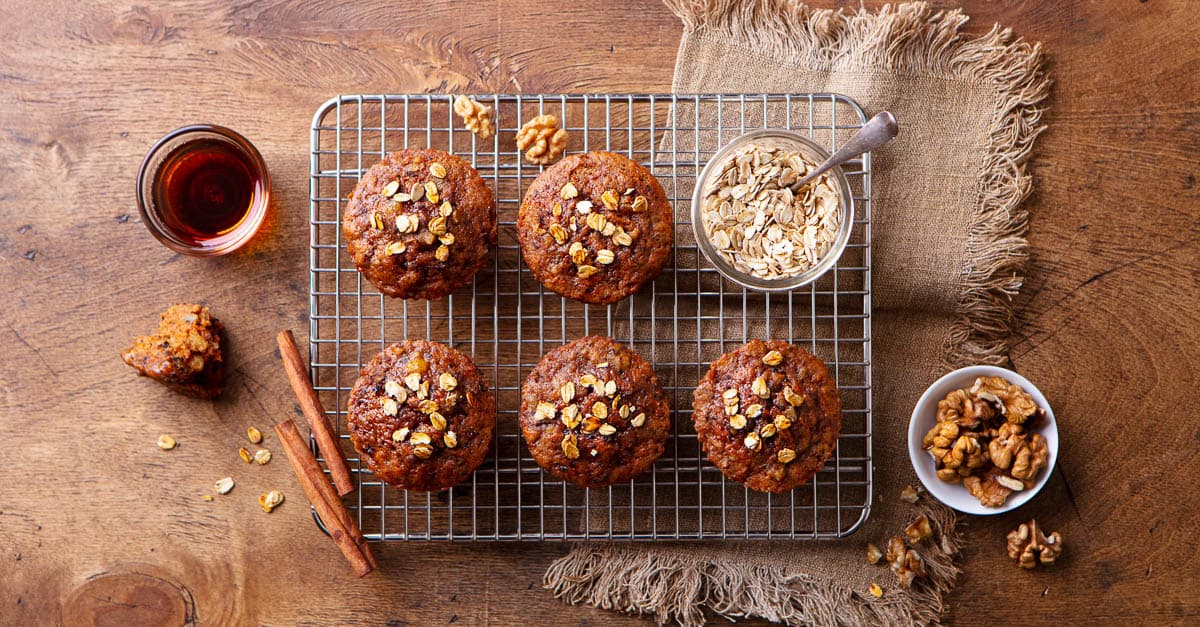 Carrot oat muffins, cupcakes, cakes on cooling rack. Wooden background. Top view.