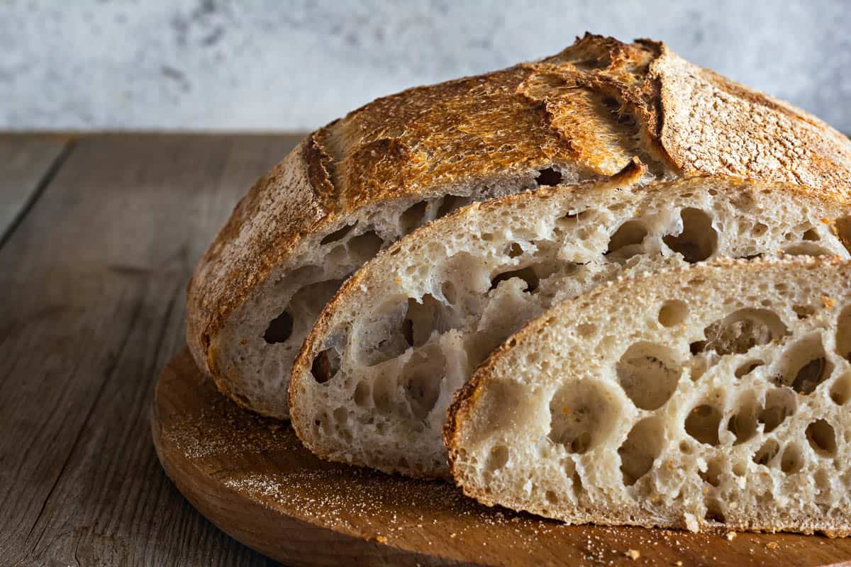 Fresh crispy homemade bread with whole grain flour sourdough(unleavened) on a wooden background.