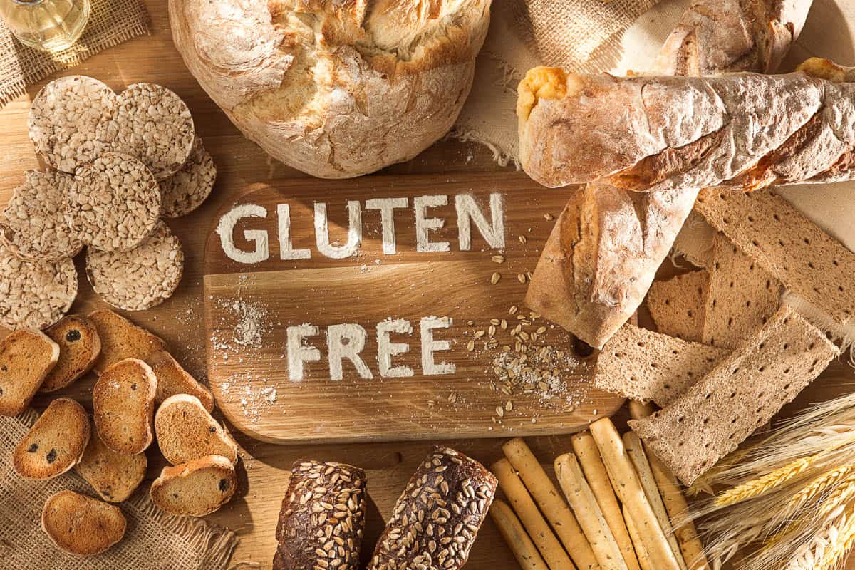 Gluten free food. Various pasta, bread and snacks on wooden background from top view.