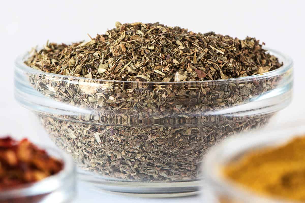 Mix of dry Italian Herbs in glass bowl.