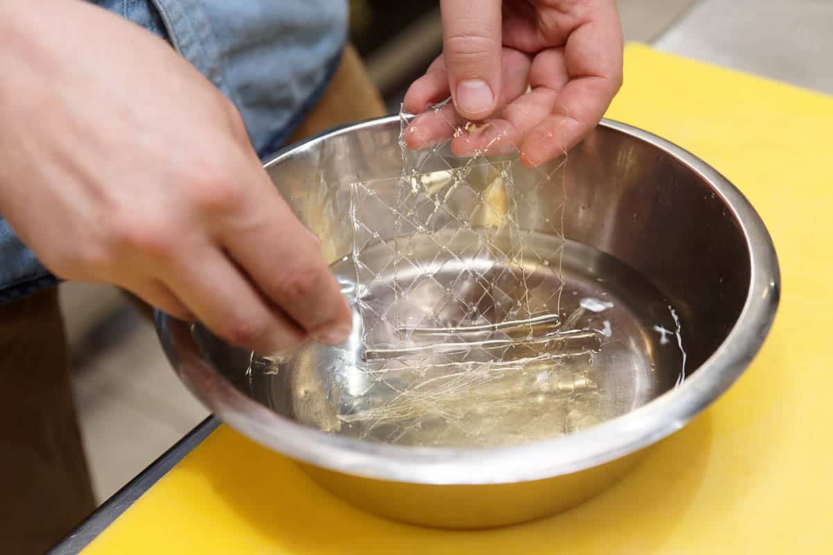 Chef is soaking gelatin sheets in cold water.