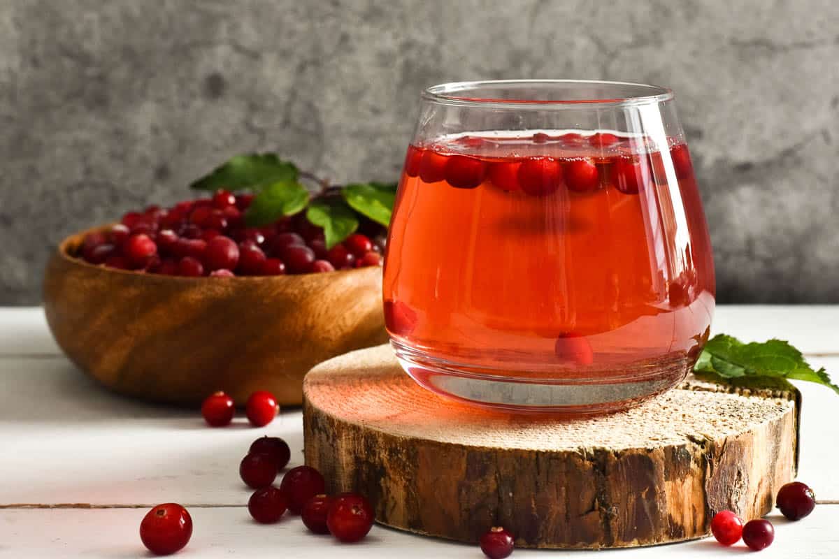 Glass Refreshing cocktail and bowl with cranberry
