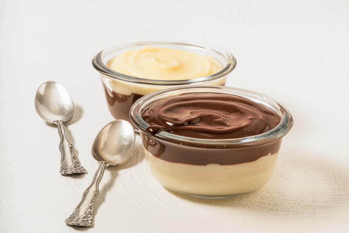 Vanilla and chocolate pudding on white background.