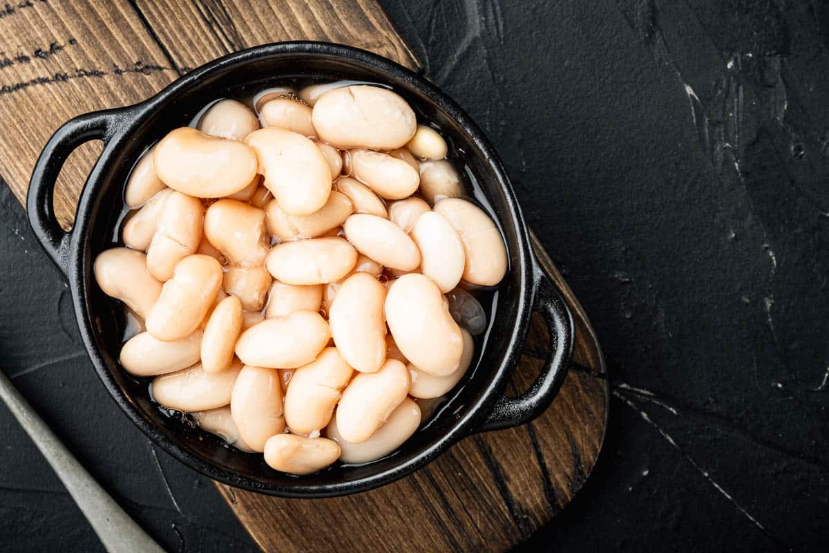 white beans in black dish with handles.