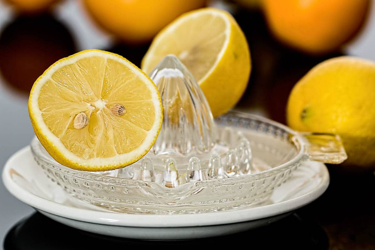 halved lemons with glass squeezer