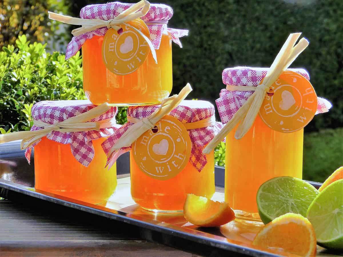 four jars of orange marmalade with fresh lime and orange