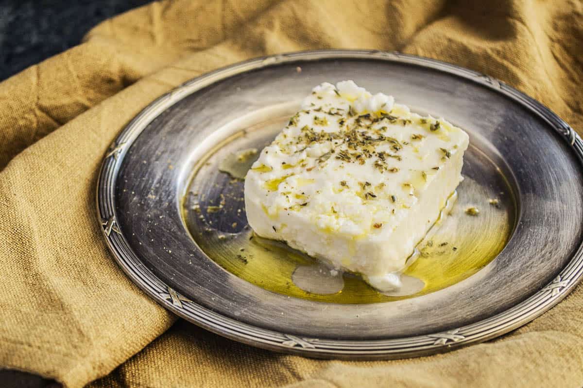 fresh feta cheese topped with dried herbs and olive oil