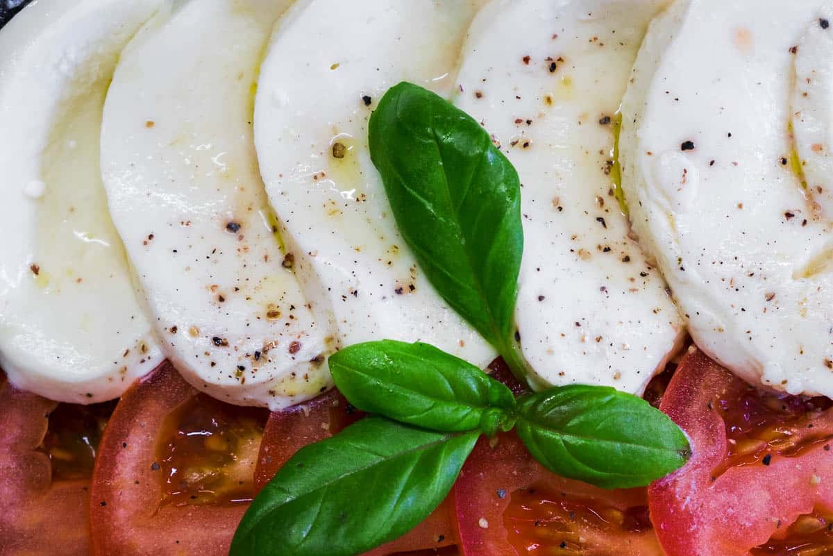 sliced mozzarella with tomatoes and basil