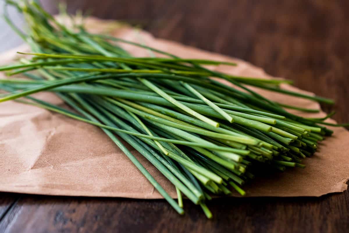 Fresh Chives on wooden surface.