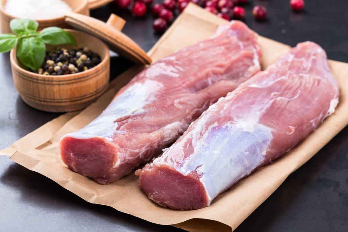 Raw pork tenderloin on craft paper ready to cook.