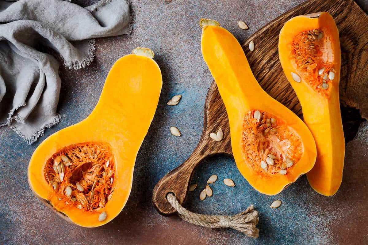 Butternut squash on wooden board over rustic background.