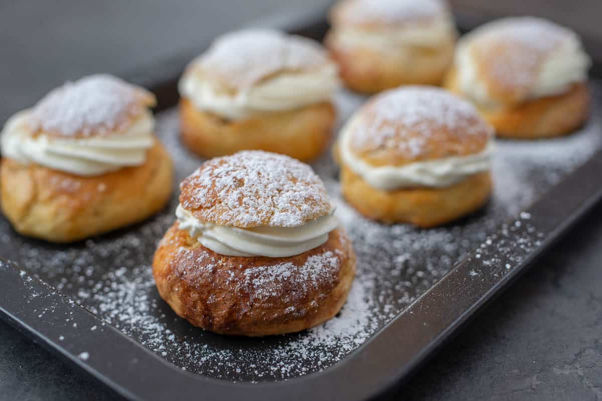 swedish semlor pastry topped with powdered sugar.