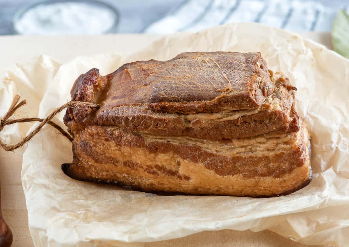 Large slice of smoked pork bacon with layers of meat.