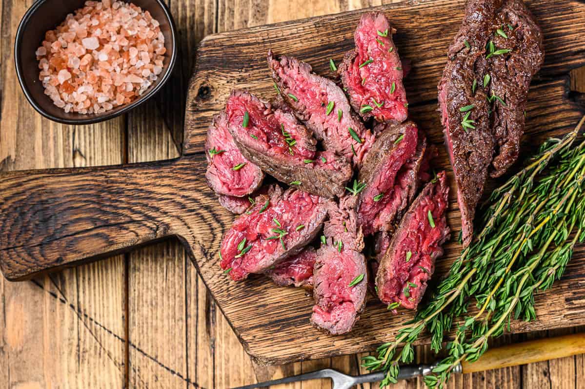 Sliced grilled machete skirt meat beef steak on a wooden cutting board. wooden background. 