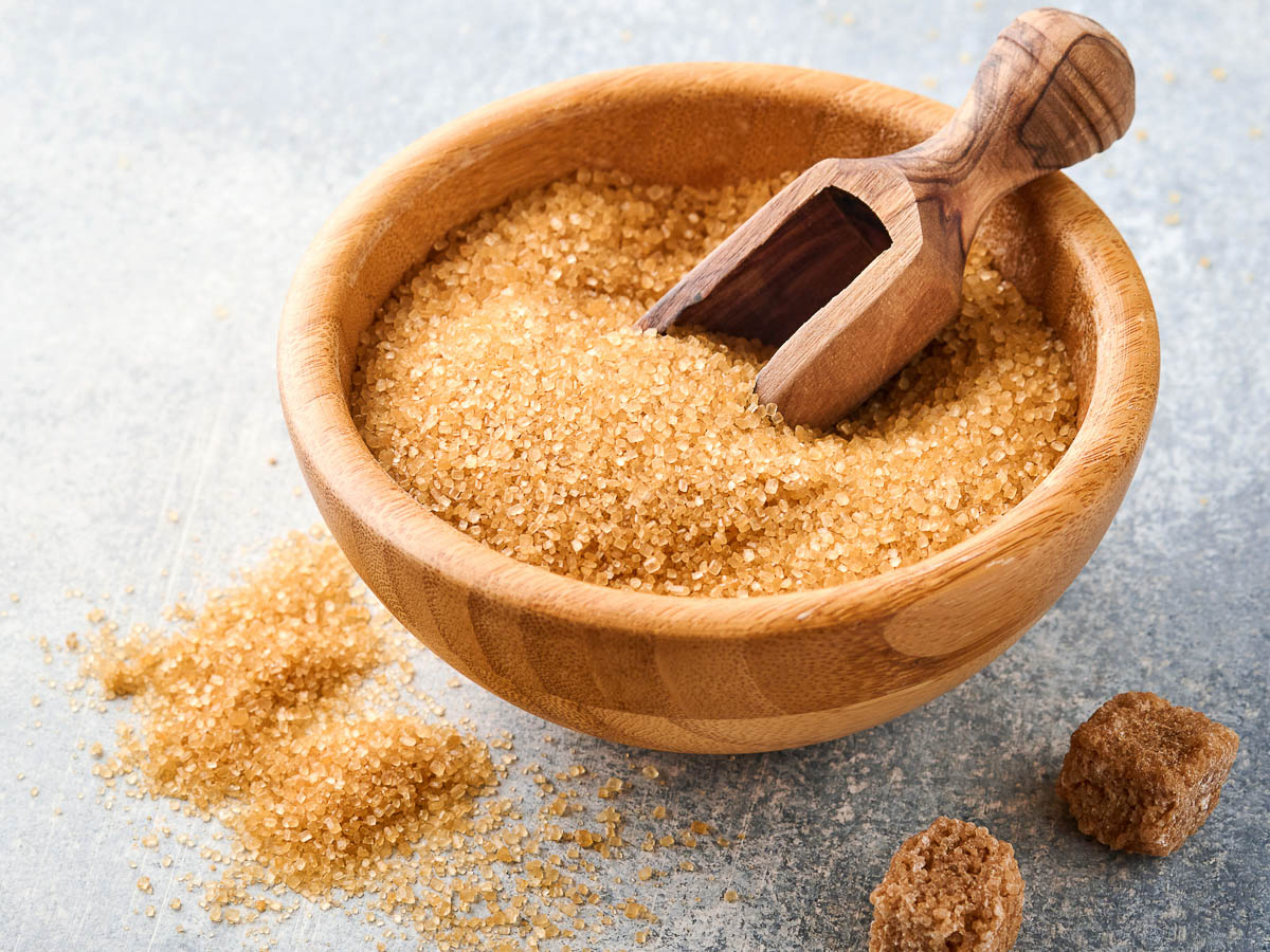 Cane sugar cube in bamboo bowl on gray table concrete background.