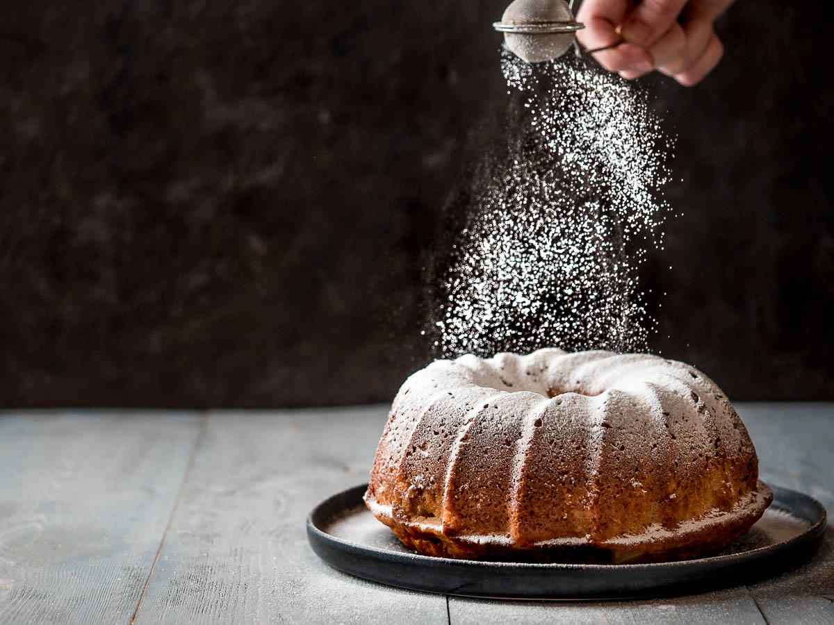 Powder sugar falls on fresh perfect muffin cake.