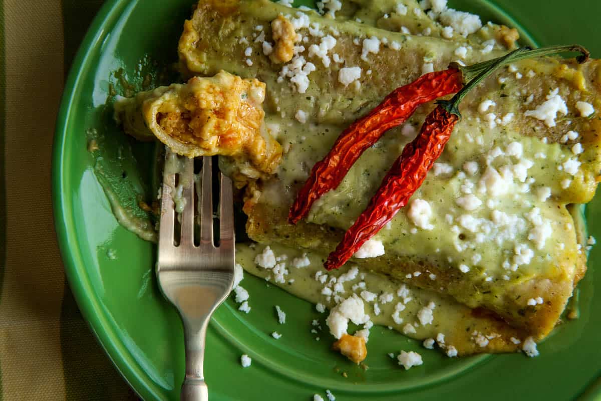 Mexican enchiladas with creamy poblano pepper sauce and queso fresco cheese.