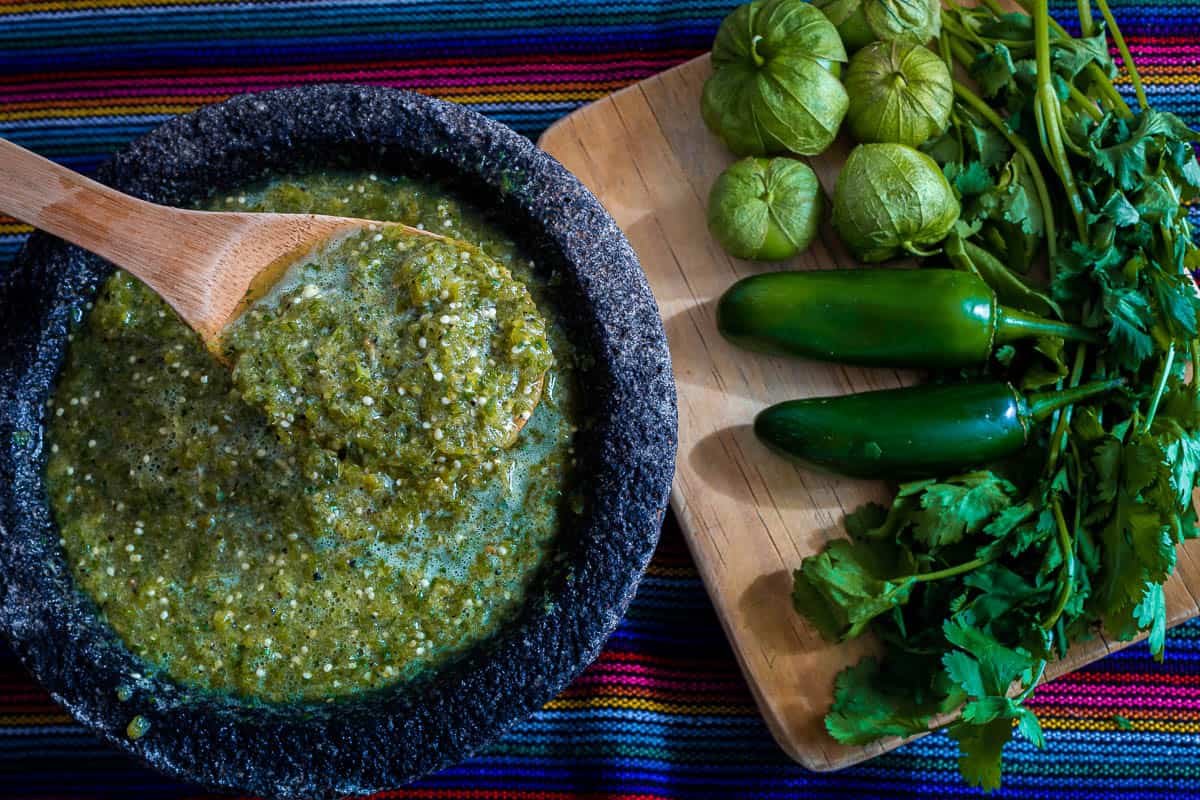 ready-to-chop ingredients to make a green sauce in a molcajete.