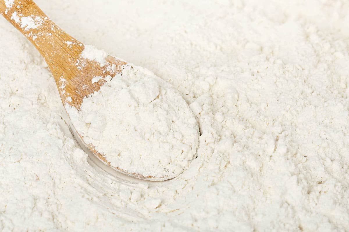 close up of wooden spoon in flour.