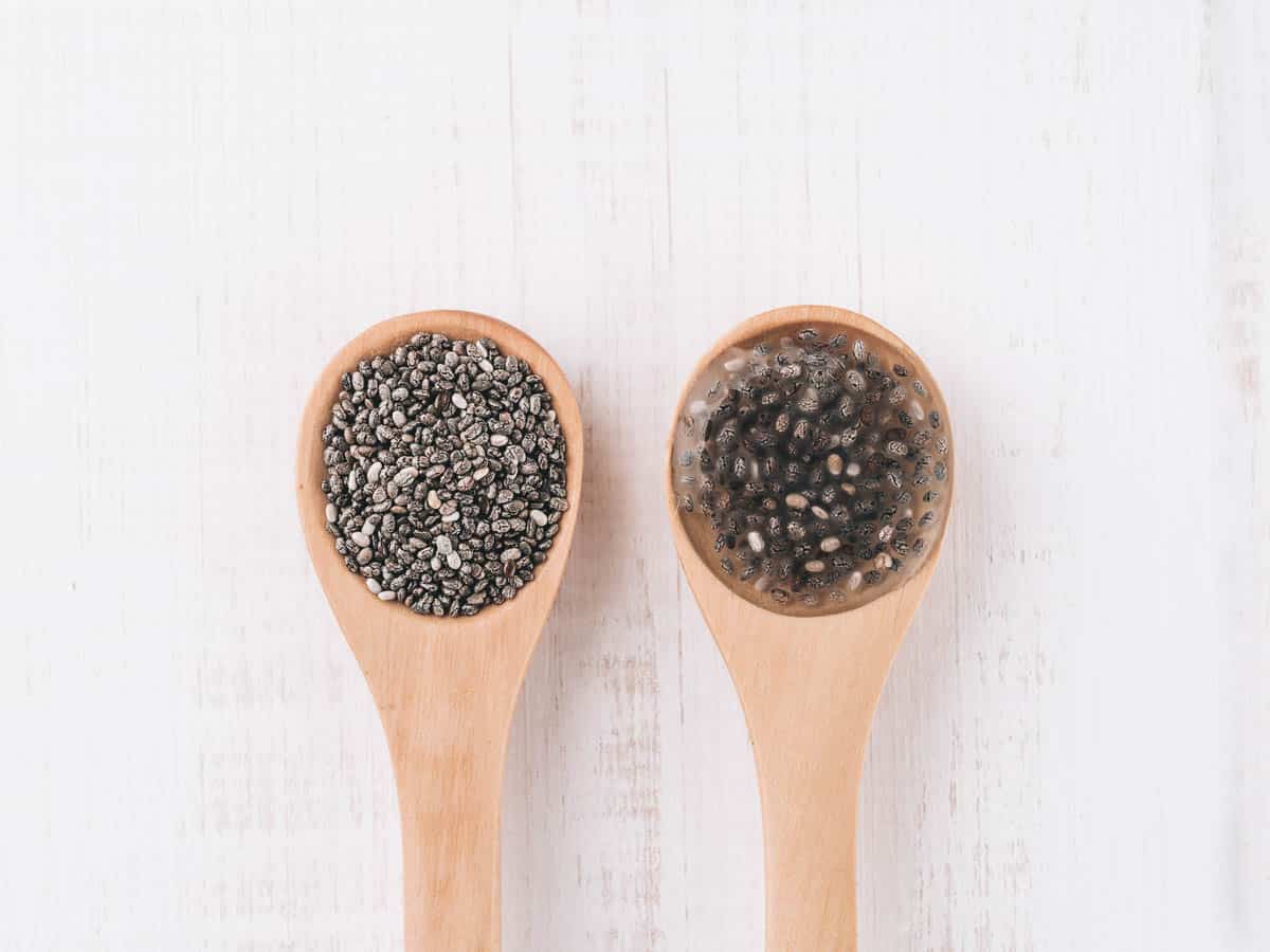 Dry chia seeds and wet chia seeds or chia-egg in wooden spoons.