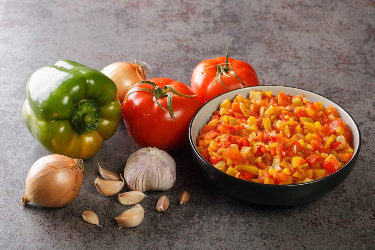 Homemade fresh sofrito sauce from summer vegetables close-up in a bowl on the table.