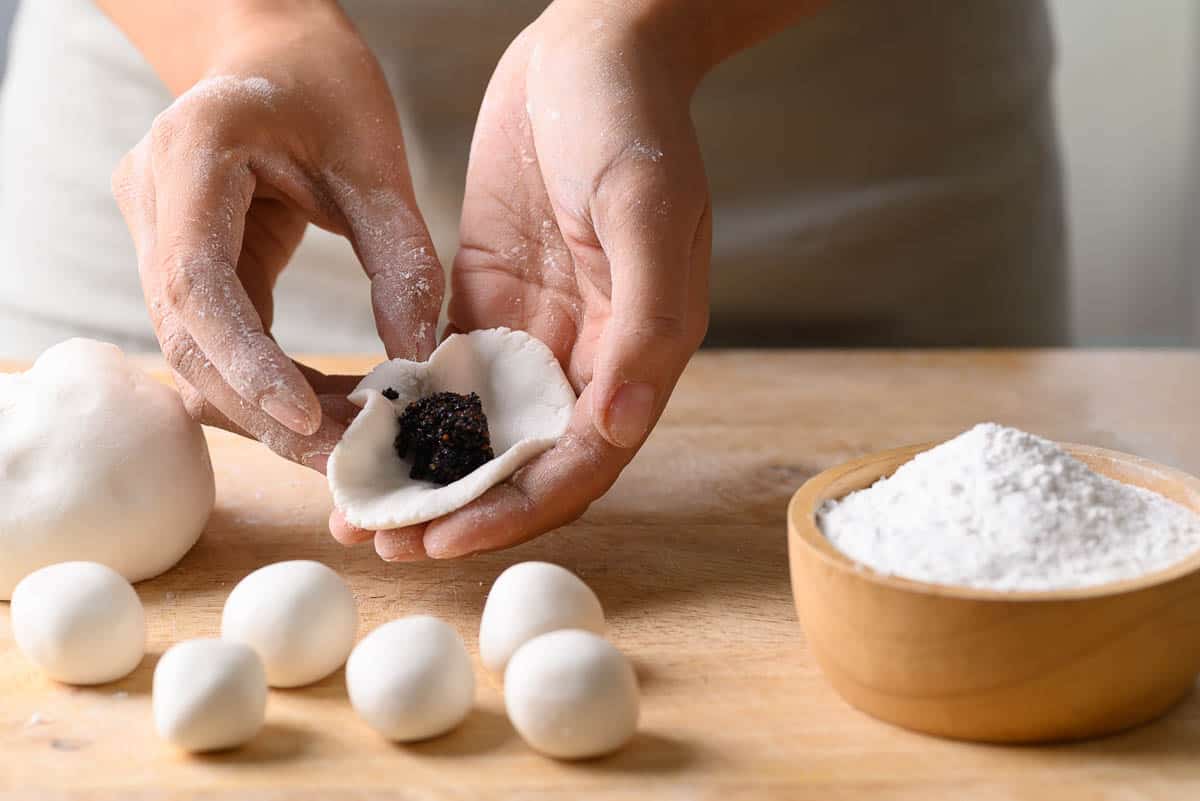 Hand making Tangyuan, Chinese dessert made of ball glutinous rice flour and filled with black sesame, Sweet rice ball.