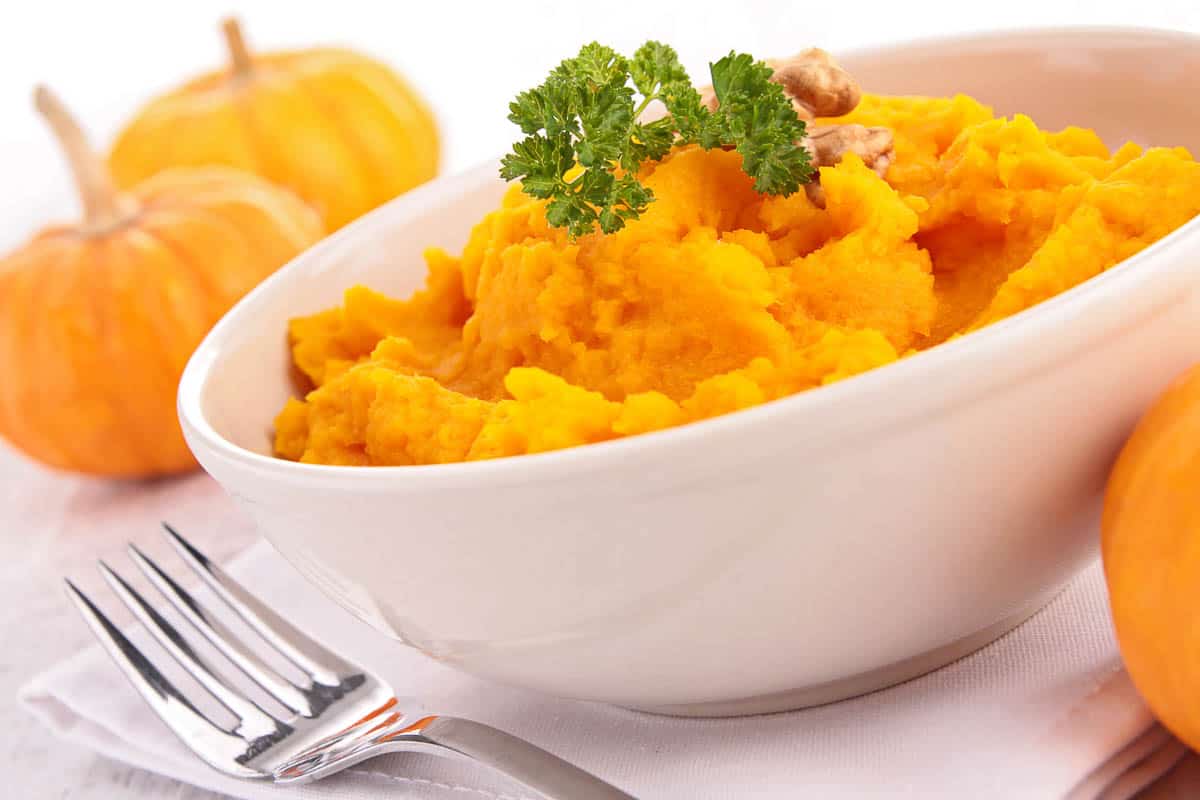 Mashed pumpkin puree in white bowl.